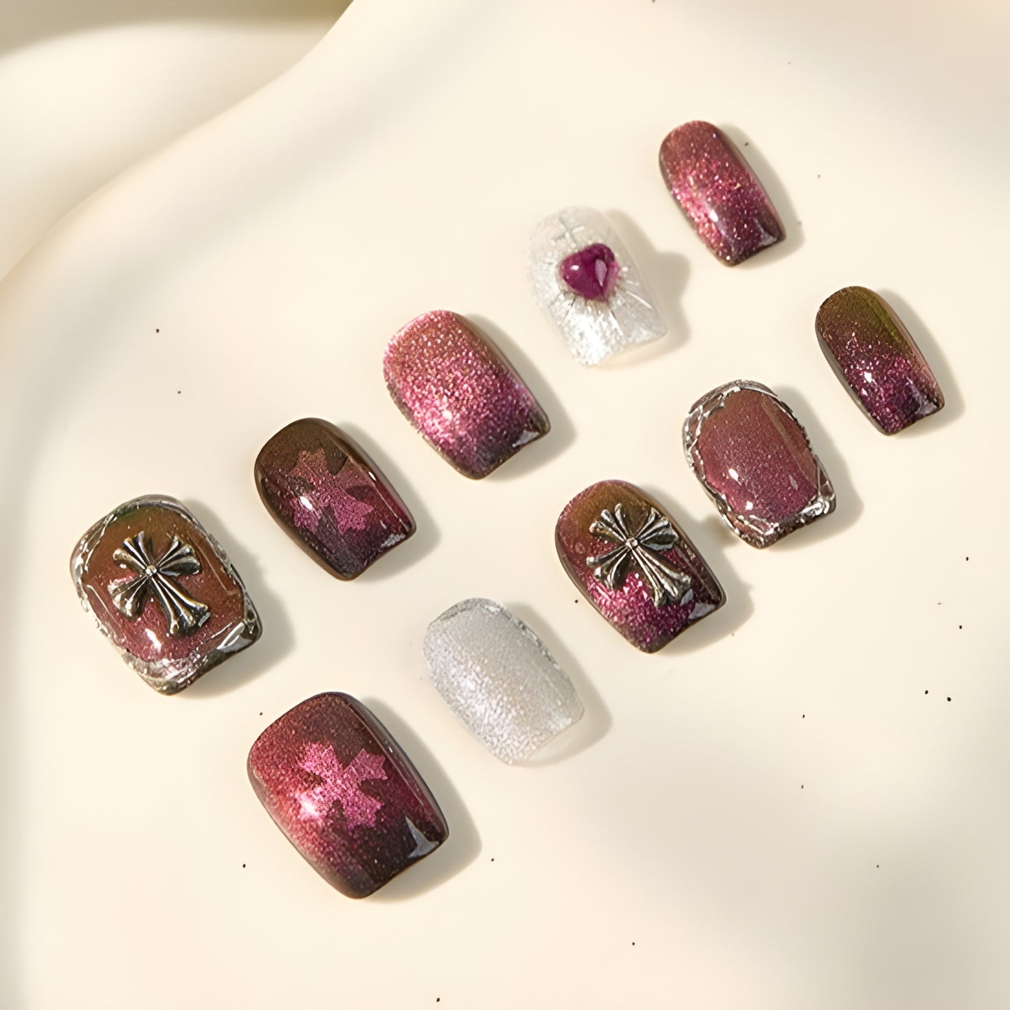 Short square nails in garnet with metallic crosses and shimmering accents”
garnet-eclipse-heart-accent