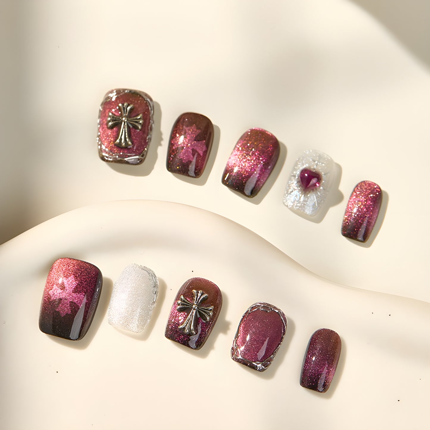 10-piece Garnet Eclipse press-on nail set with chrome frames, crosses, and cat eye finish