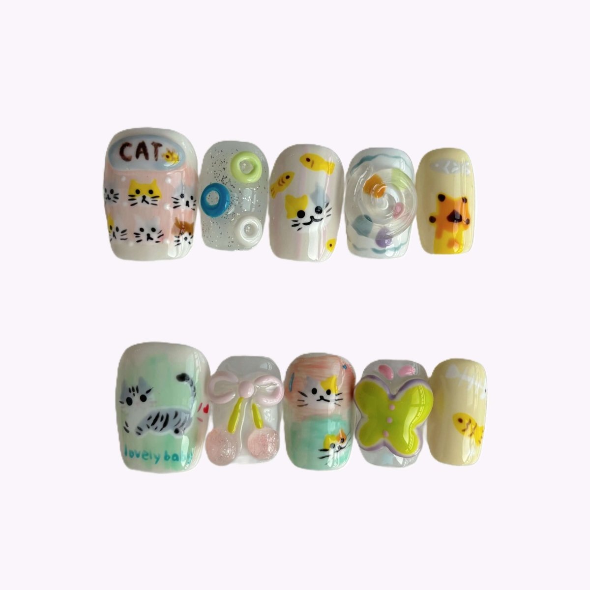 Ten-piece pastel nail set with hand-drawn cats, candy swirls, green butterfly and the word 'Lovely Baby