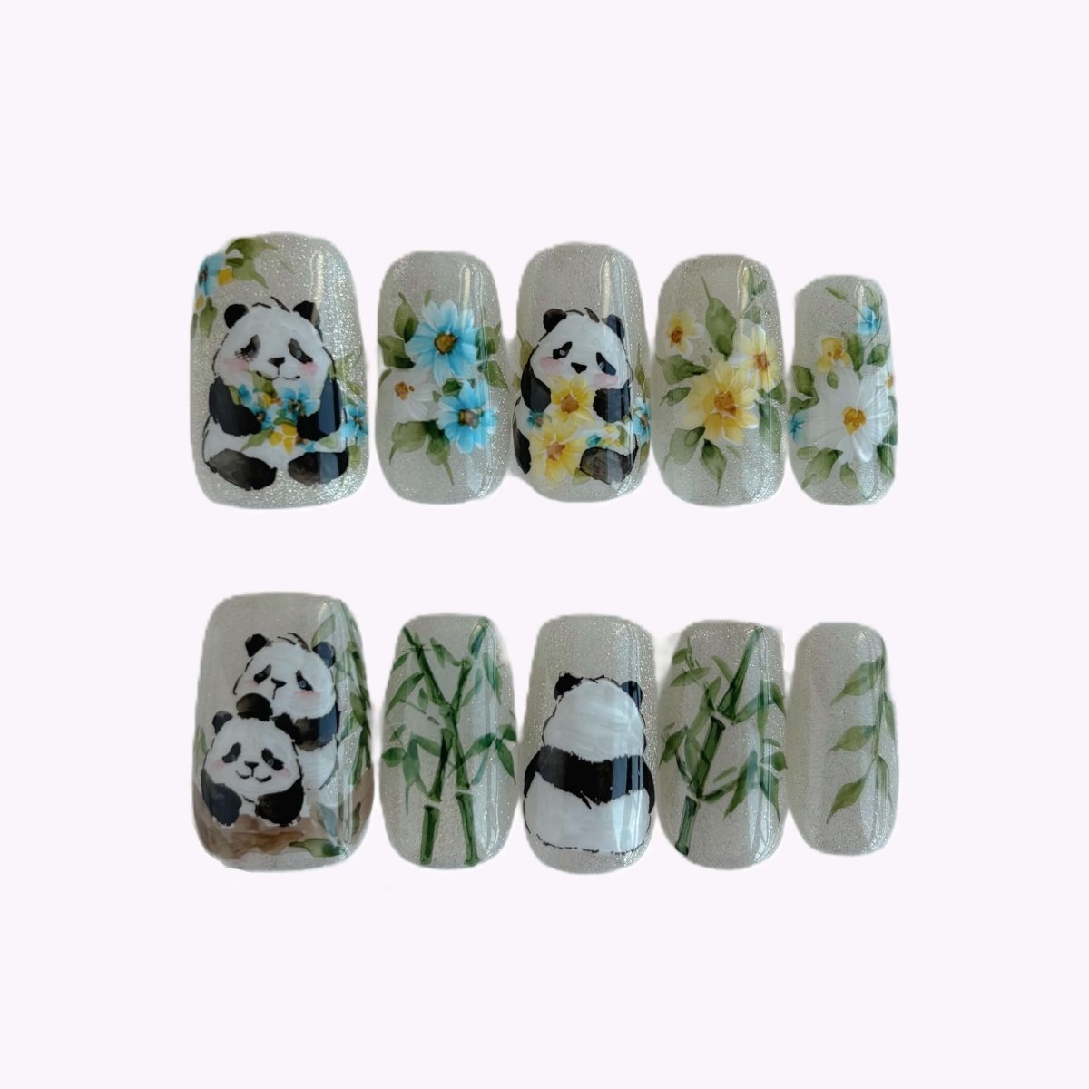 Full set of Bamboo Blossoms press-on nails in clear case showing pandas and flowers