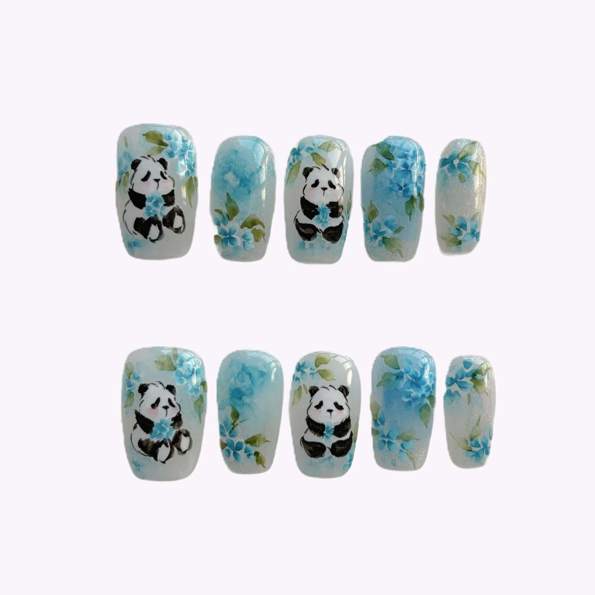 Flat lay of Blue Bamboo Bloom press-on nail set with 10 handmade designs