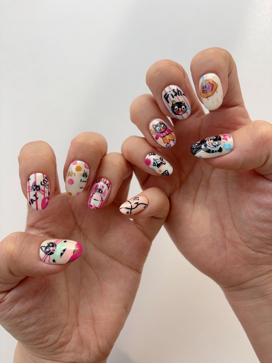 Close up of cute black cat and fish lettering nail art on press-ons