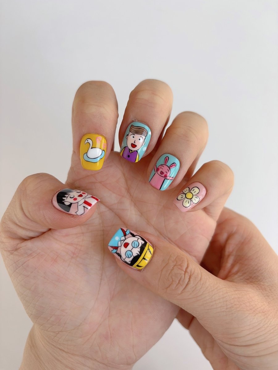Playful Y2K-style press-on nails featuring pastel colors, cute characters, and nostalgic symbols like flowers and ribbons