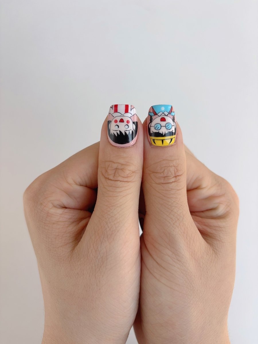 Two thumbs showing detailed kawaii nail art with cartoon girls wearing glasses and striped shirts, glossy pastel background