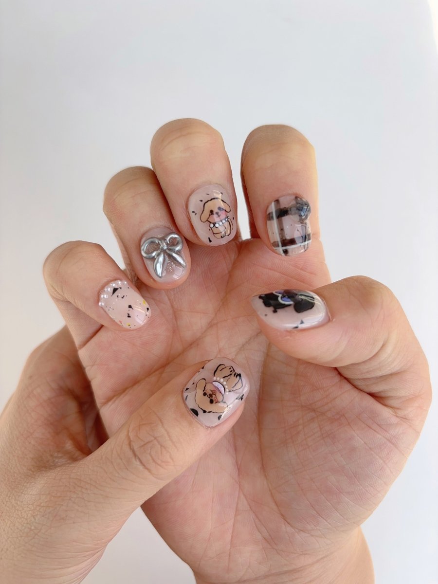 Close-up of short square press-on nails with 3D paw print, metallic silver bow, and 'My Dog' lettering