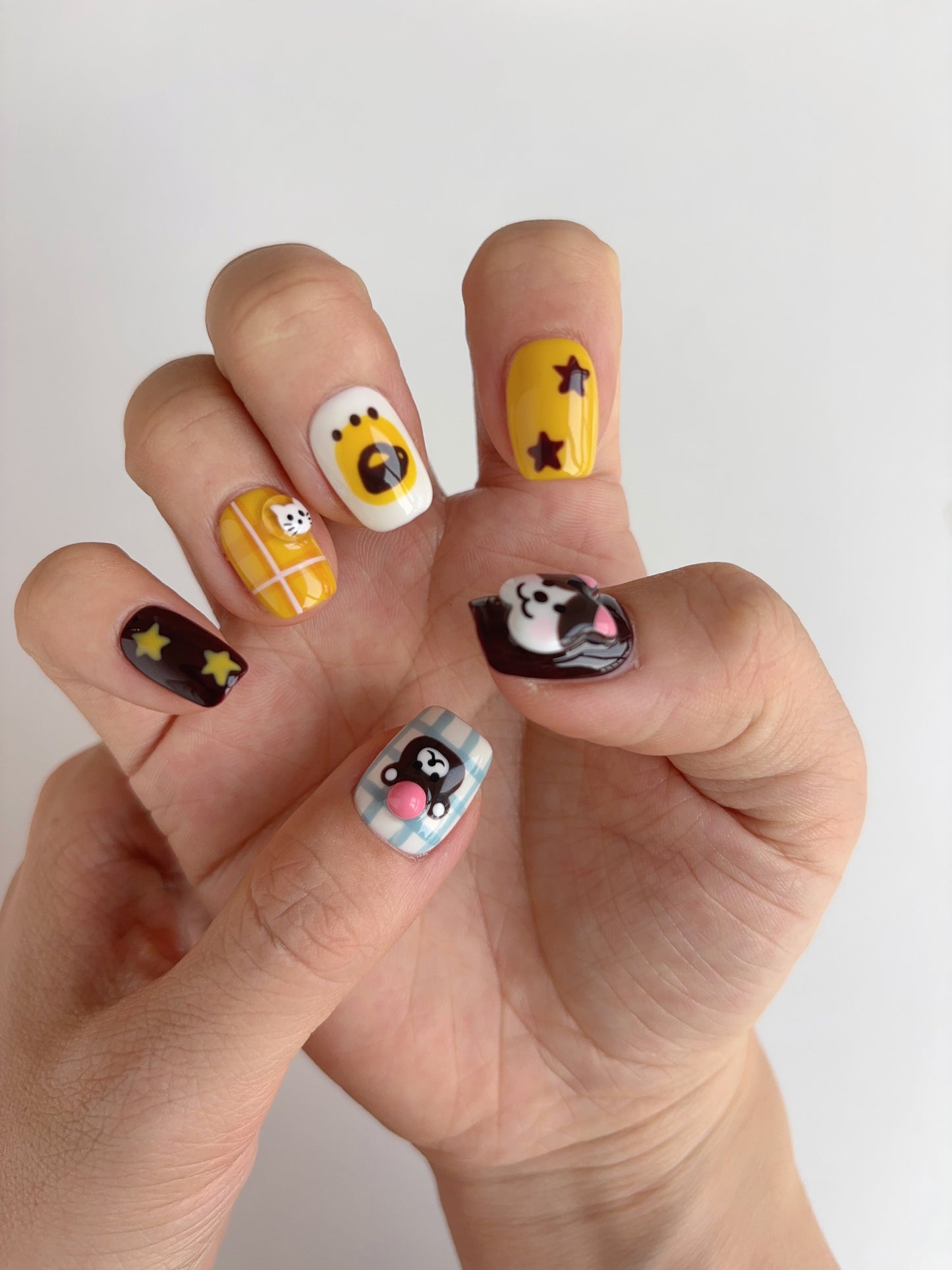 Handmade 3D press-on nails featuring bear, bunny, dog, and star designs in black, mint, yellow and pastel tones