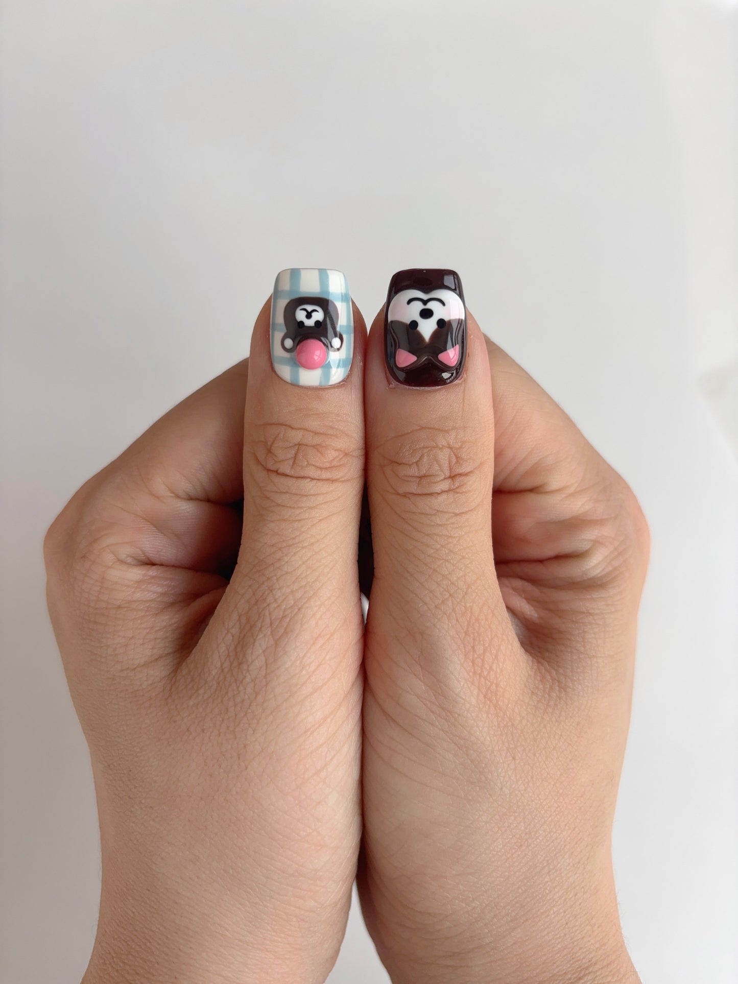 Thumbs featuring 3D bear with gumdrop nose and dog with floppy ears on short square press-on nails