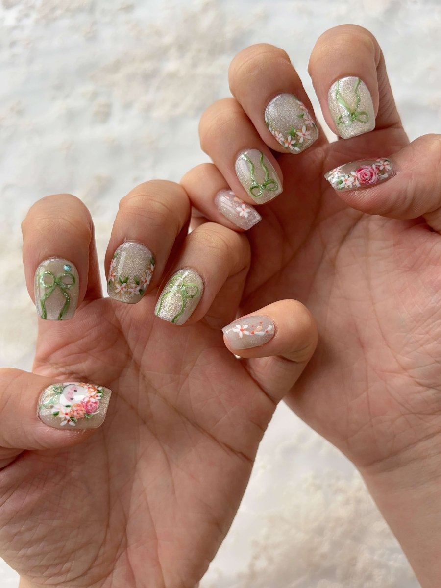 Close-up of floral wreath and green bow nail art on Bunny in Bloom handmade nails