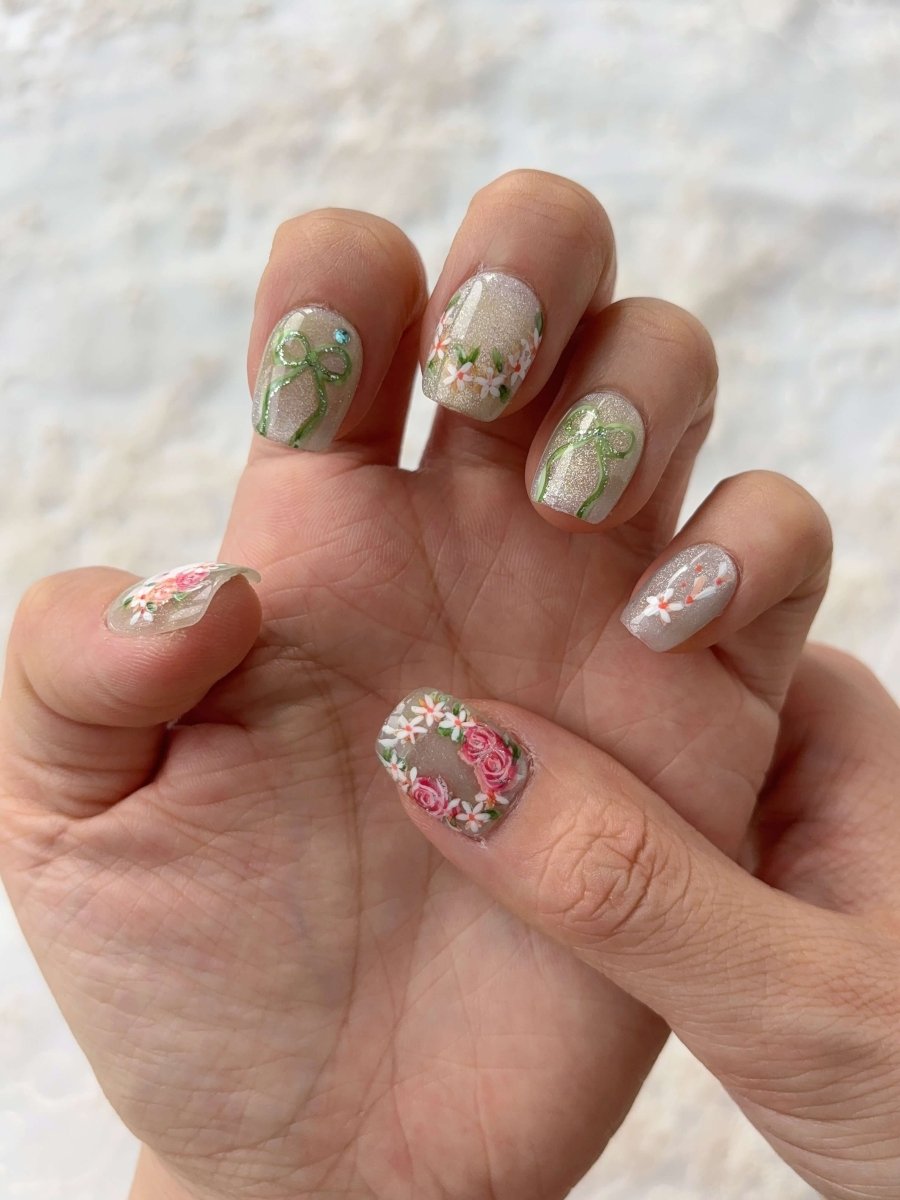 Hand with Bunny in Bloom press-on nails featuring 3D floral crown and pastel shimmer base