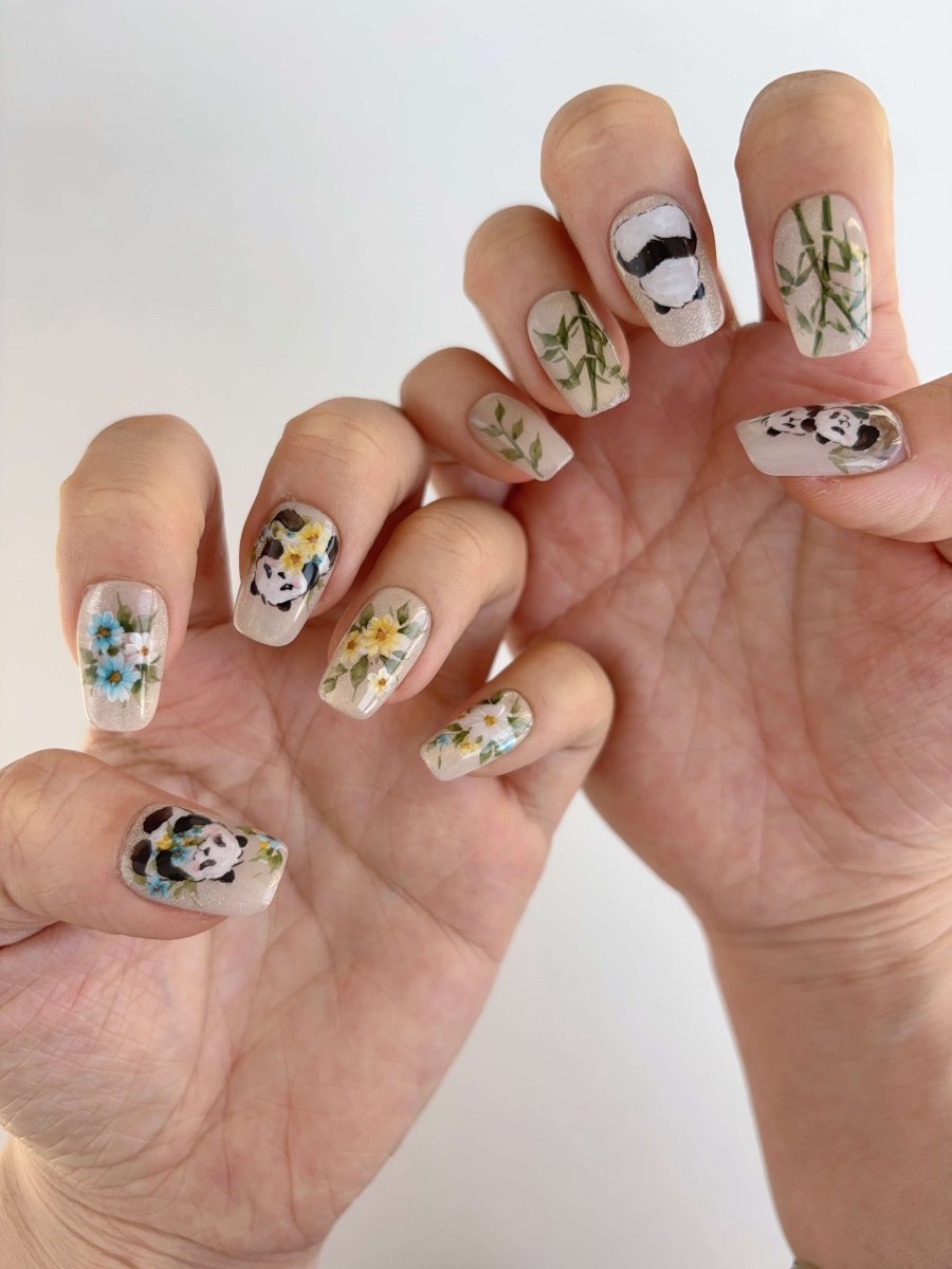 Hand-painted panda press on nails with bamboo and floral accents in long square shape