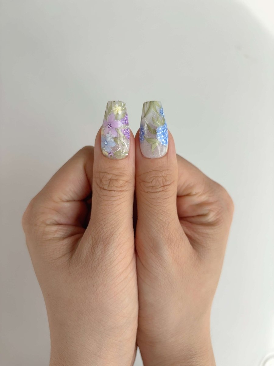 Two thumbs with soft pastel botanical nail art