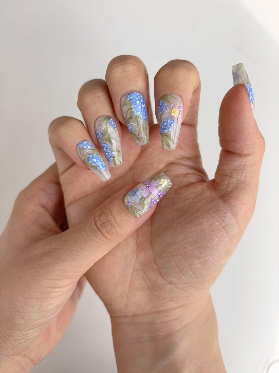 Closeup of long coffin nails with delicate painted flowers