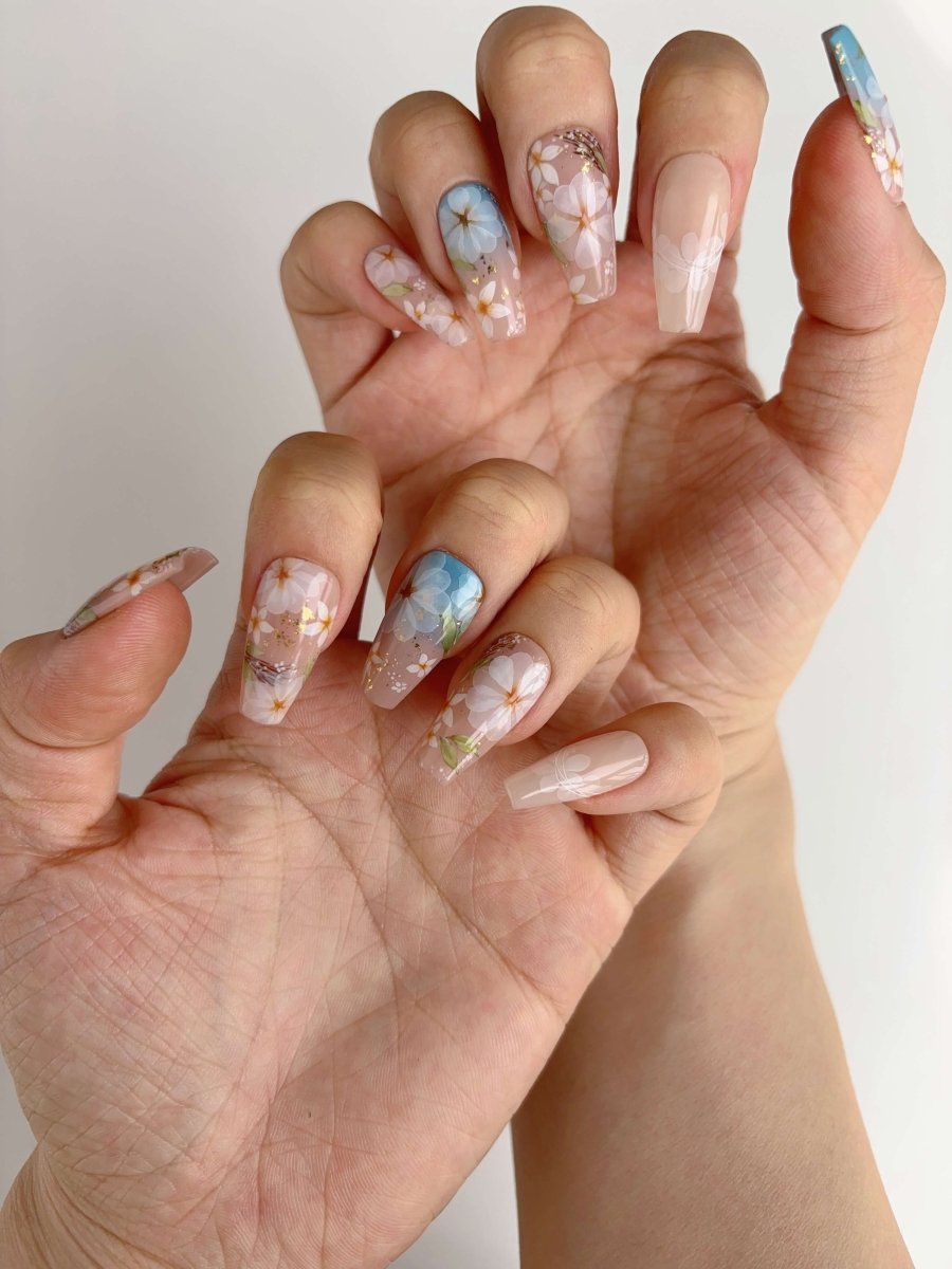 Soft spring floral press-on nails in coffin shape with pink, nude, and blue hues
