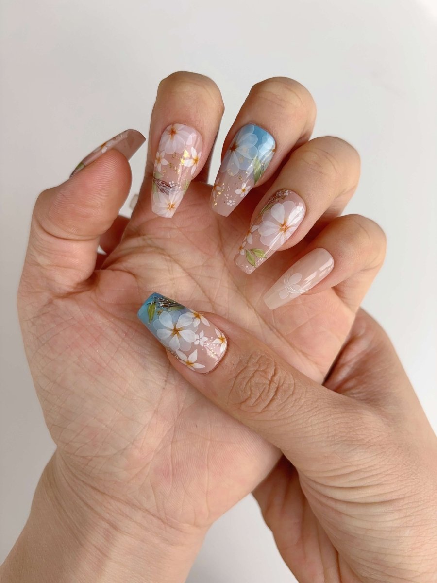 Side view of Daisy Skies floral press-on nails with ombré pastel tones and gold foil accents