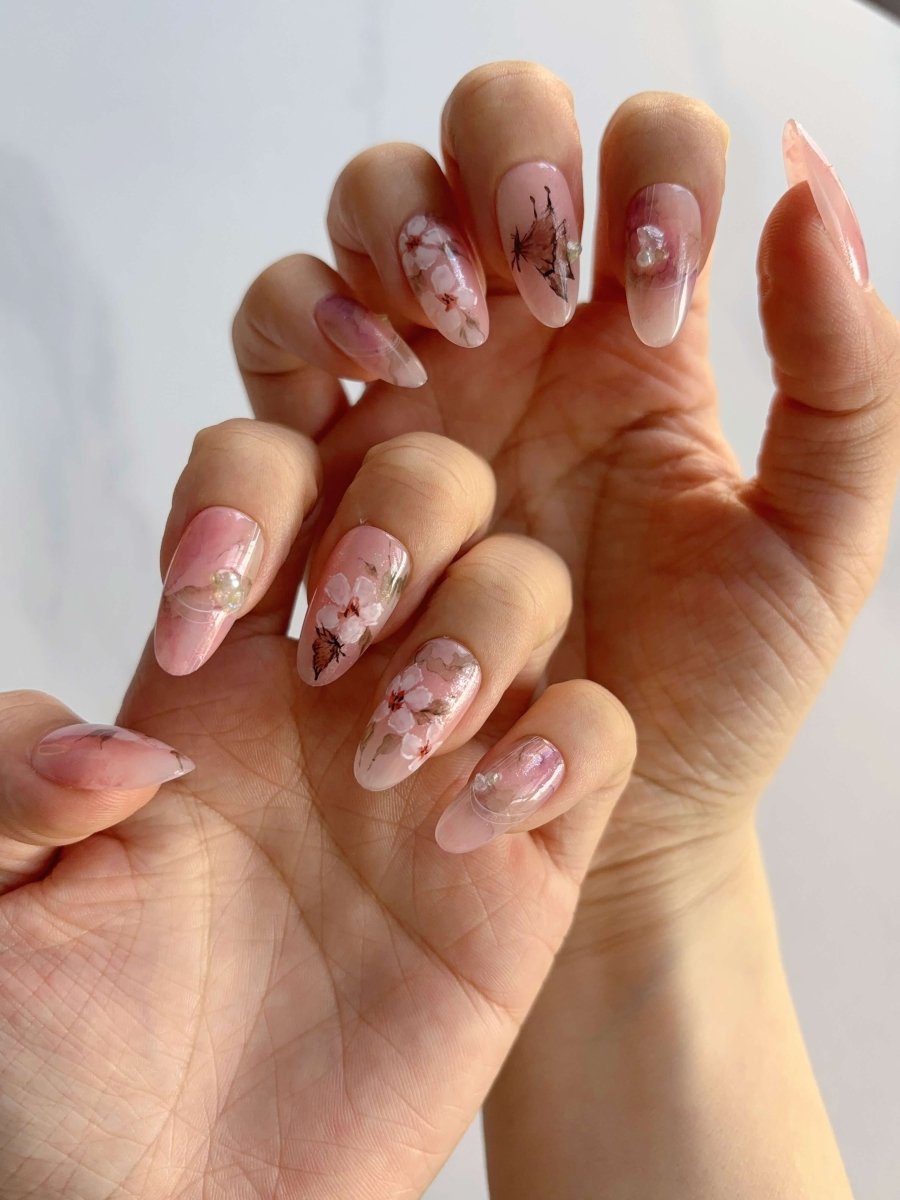 Soft pink cherry blossom nail art on both hands with transparent jelly finish