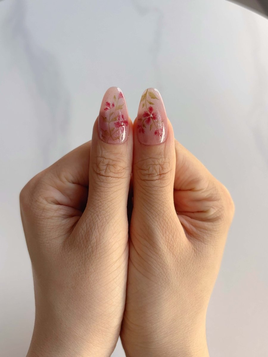 Almond-shaped press-on nails with burgundy shimmer and nude contrast
