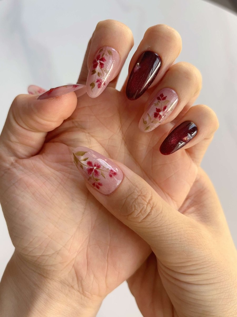 Side view of Crimson Bloom nails with gold foil and pearl embellishments