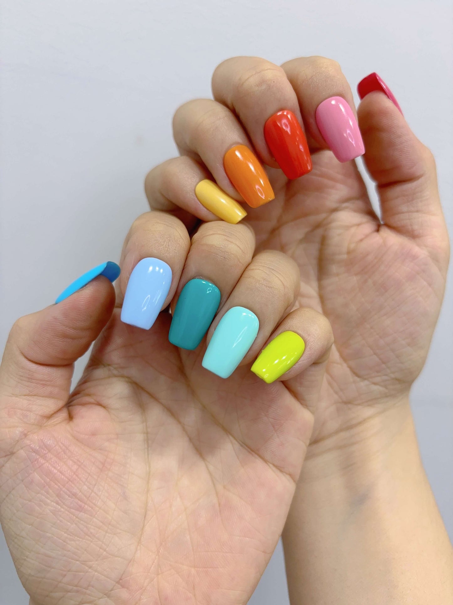 Hand wearing Technicolor Tips nails with gradient rainbow colour on each finger