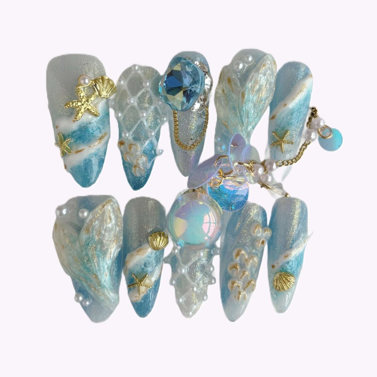 Mermaid fantasy press-on nail set in case featuring 3D tails, pearls, shells, and ocean textures