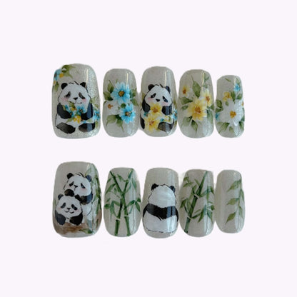 Full set of Bamboo Blossoms press-on nails in clear case showing pandas and flowers
