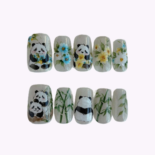 Full set of Bamboo Blossoms press-on nails in clear case showing pandas and flowers