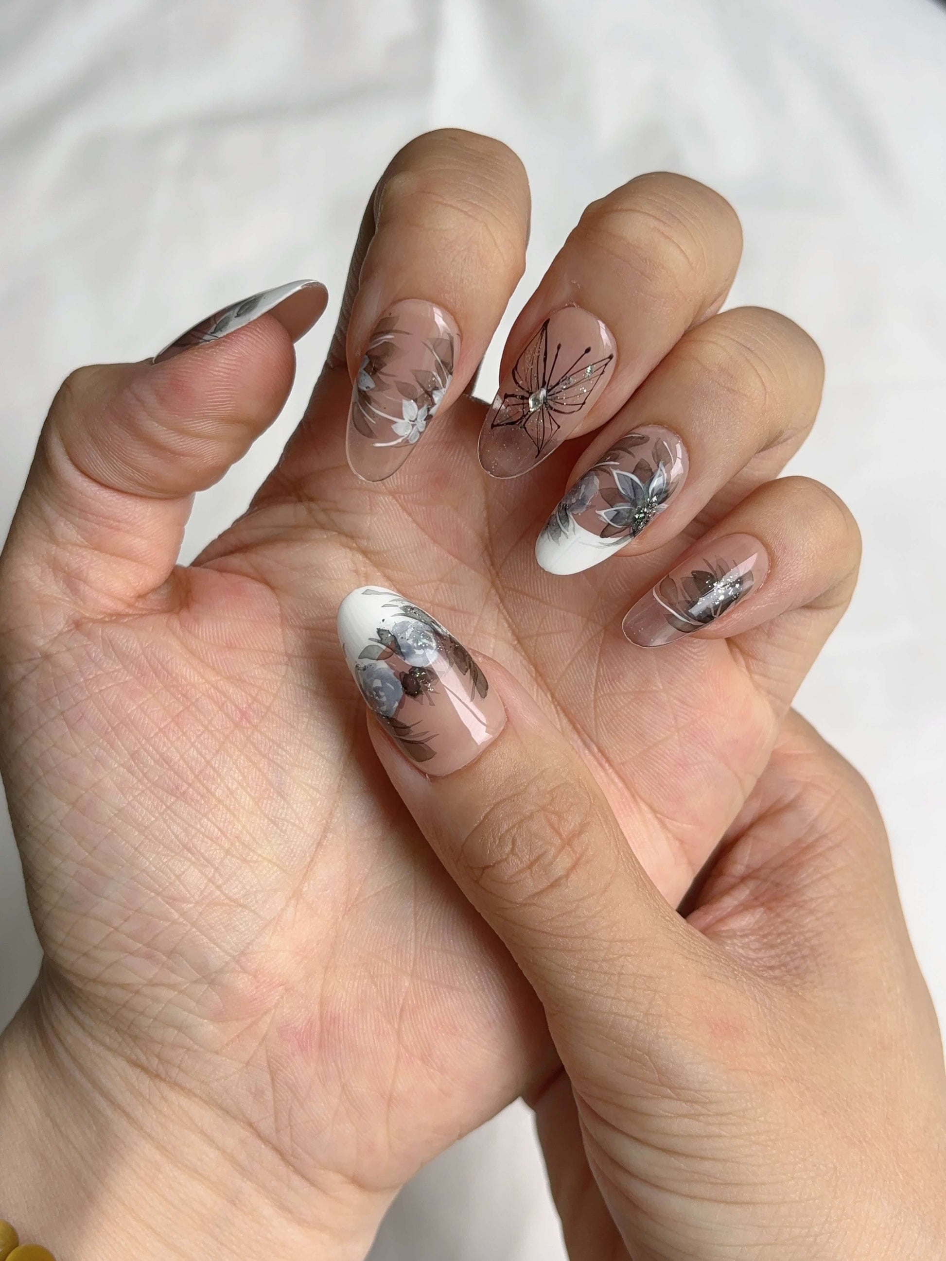 Twilight Garden press-on nails featuring florals, butterflies, and neutral tones
