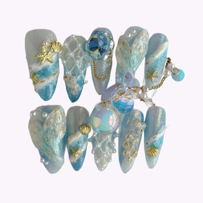 Mermaid fantasy press-on nail set in case featuring 3D tails, pearls, shells, and ocean textures