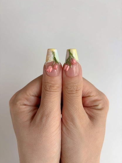 Close-up of thumb nails featuring coral rosebuds on a glossy nude base