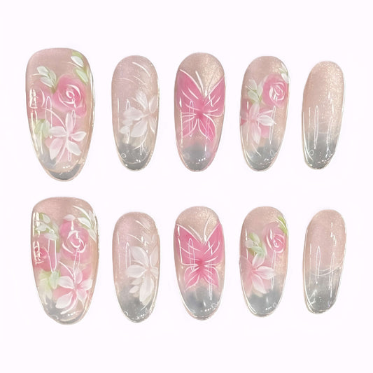Flat lay of Rosé Reverie press-on nails with soft pink rose and butterfly designs