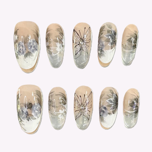 Full view of all 10 Twilight Garden press-on nails with floral illustrations and neutral accents